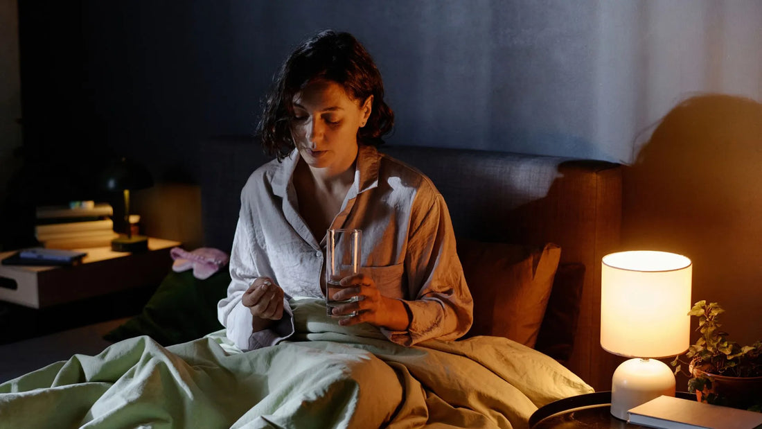 Femme dans son lit qui prend un médicament pour faire baisser son cortisol